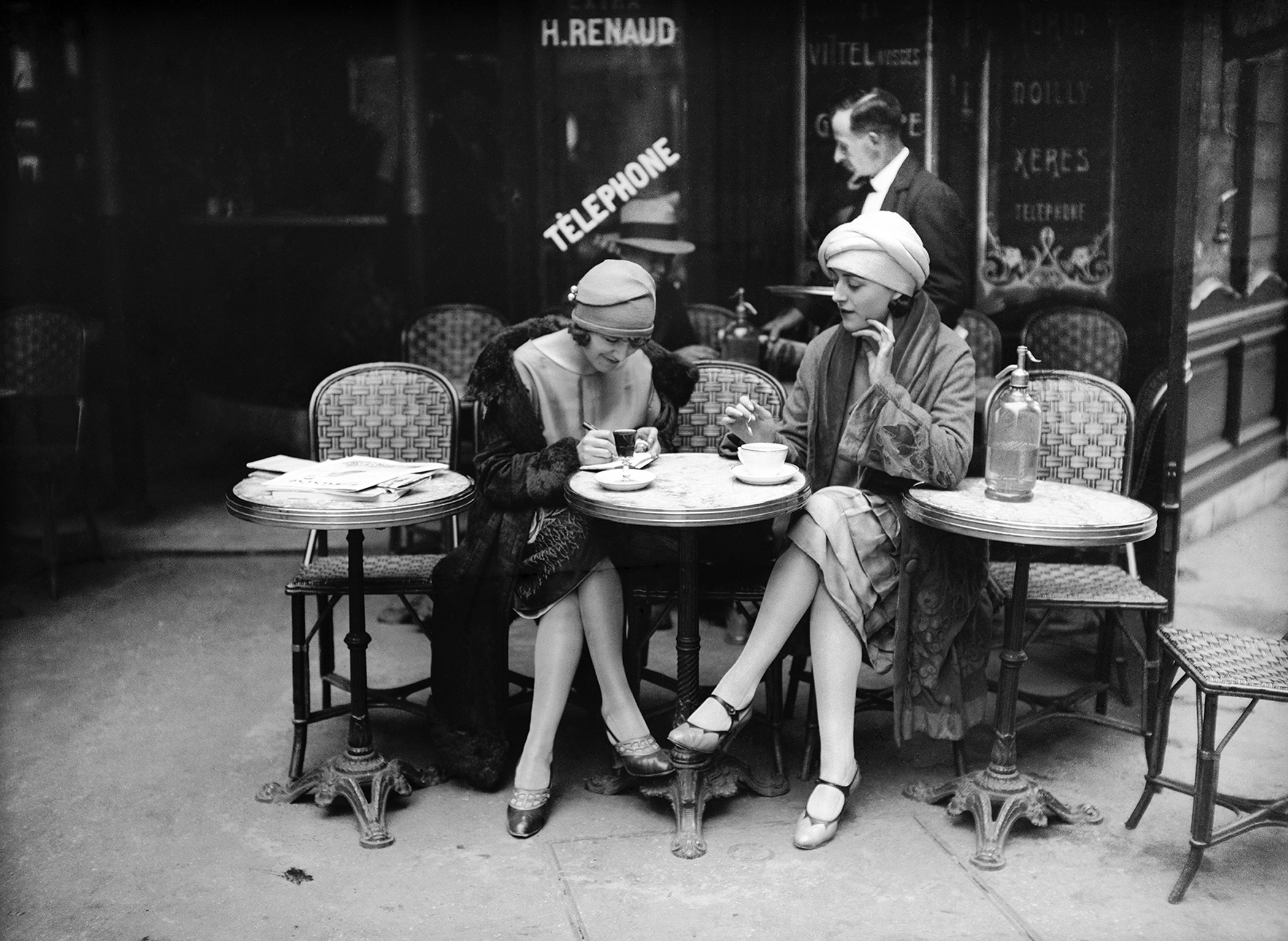Two elegant women at a Paris café during the Roaring Twenties